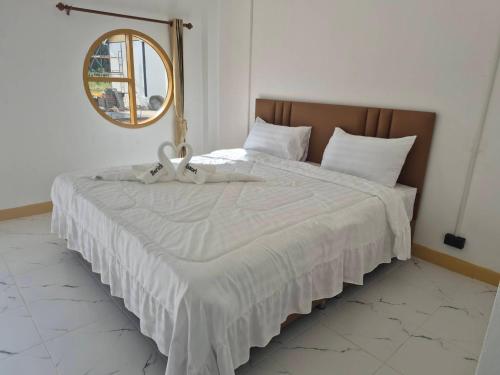 a bedroom with a large bed with a mirror at บีริช รีสอร์ท in Ban Pet