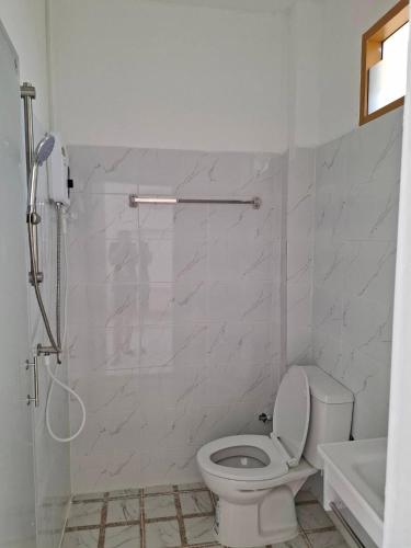 a white bathroom with a toilet and a shower at บีริช รีสอร์ท in Ban Pet