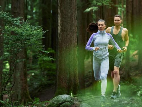 a man and a woman running through a forest at Fairmont Waterfront in Vancouver