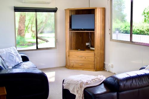 a living room with a couch and a flat screen tv at BIG4 Wilsons Prom Holiday Park in Yanakie