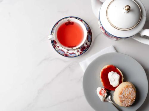 a table with a cup of tea and a plate of food at Fairmont Hotel Vancouver in Vancouver