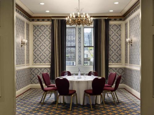 a dining room with a table and chairs and a chandelier at Fairmont Hotel Vancouver in Vancouver