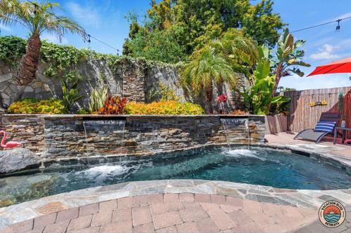 a small pool with a stone retaining wall and a patio at Oceanside Comfort Walk in SPA Gym Fun in Oceanside