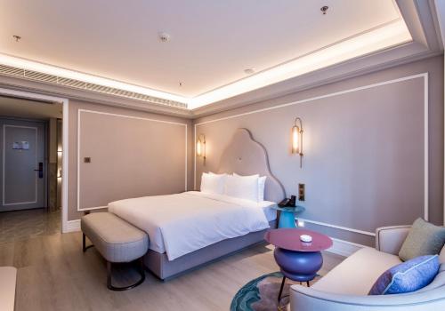 a hotel room with a bed and a couch at Mercure Hotel Changchun Hengxing in Changchun