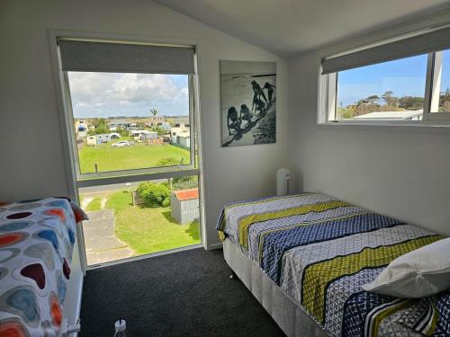 a bedroom with two beds and a window at Pyramid house in Karikari Peninsula