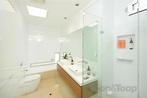 a white bathroom with a toilet and a sink at Charming Sandstone Villa in the heart of Norwood in Rose Park