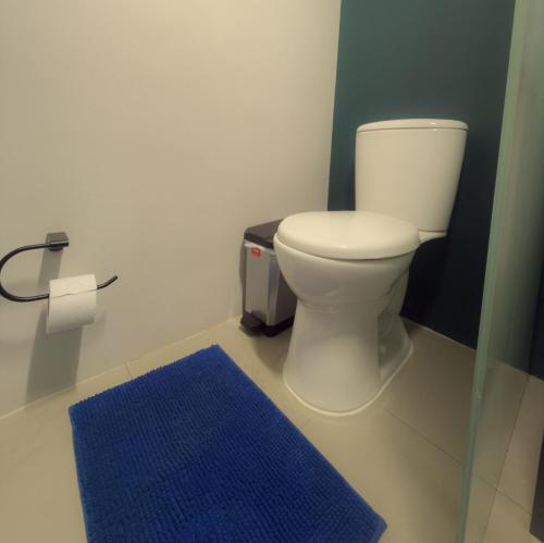 a bathroom with a toilet and a blue rug at Apartamento Central Bogota in Bogotá