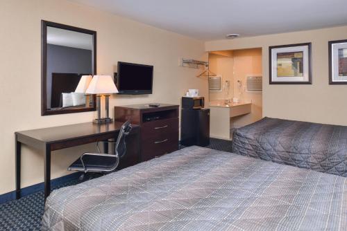 Habitación de hotel con cama y escritorio con ordenador en Golden Hill Inn-Danbury en Danbury