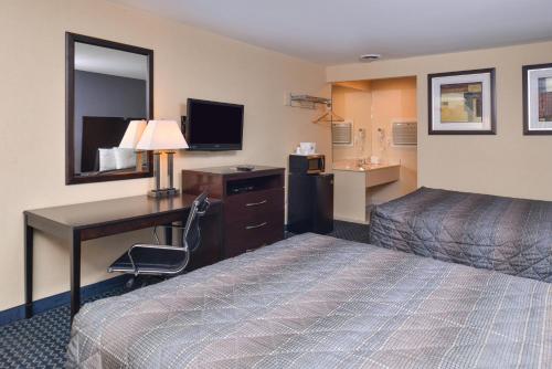 a hotel room with a bed and a desk with a computer at Golden Hill Inn-Danbury in Danbury