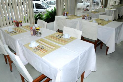 a group of tables with white table cloths at Hotel Elite in Paranavaí