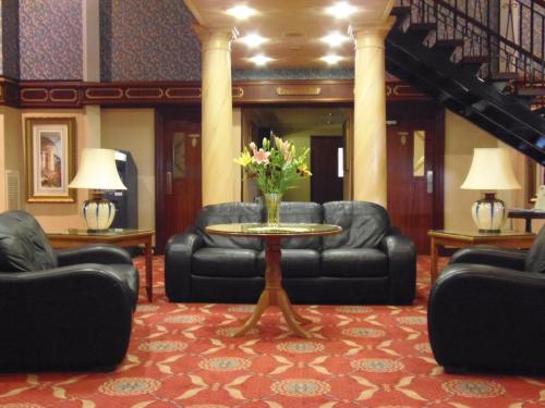 a lobby with couches and a table with flowers on it at Lakeside International Hotel in Camberley