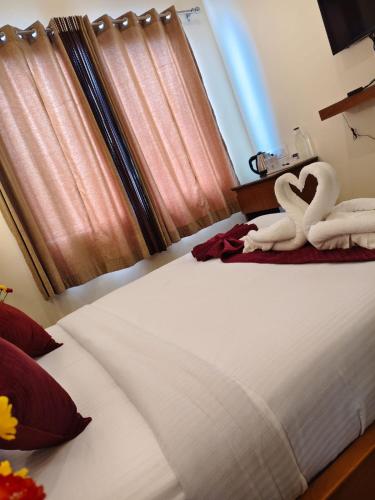 two swans sitting on top of a bed at Parasol Norling Hotel & Spa in Jāmb