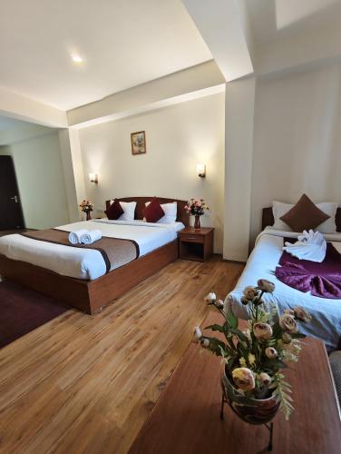 a hotel room with two beds and a table at Parasol Norling Hotel & Spa in Jāmb