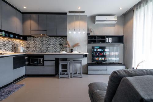 a kitchen with black cabinets and a counter top at Luxury 1BR Apt Kamala Beach Resort P409 in Kamala Beach