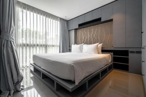 a bedroom with a large bed and a large window at Luxury 1BR Apt Kamala Beach Resort P409 in Kamala Beach