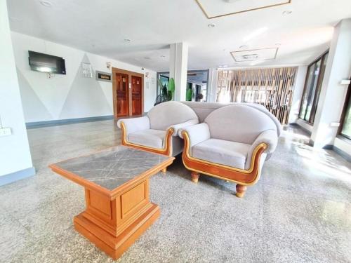 a living room with two chairs and a coffee table at New Siya in Maha Sarakham