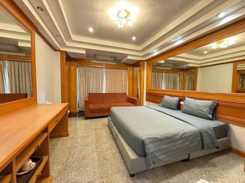 a bedroom with a bed and a couch in it at New Siya in Maha Sarakham