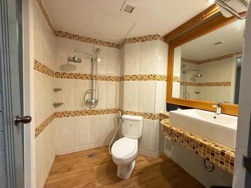 a bathroom with a toilet and a sink at New Siya in Maha Sarakham