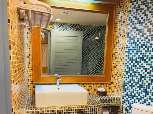 a bathroom with a sink and a mirror at New Siya in Maha Sarakham