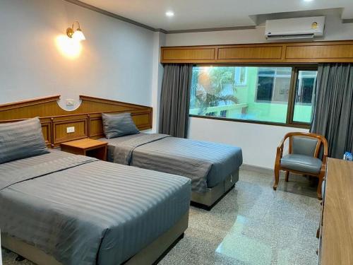 a hotel room with two beds and a window at New Siya in Maha Sarakham