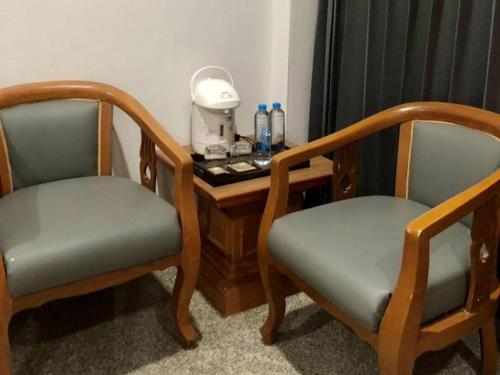 two chairs and a table with a telephone on it at New Siya in Maha Sarakham