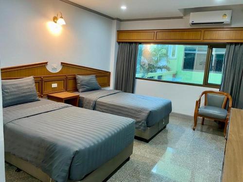 a hotel room with two beds and a window at New Siya in Maha Sarakham