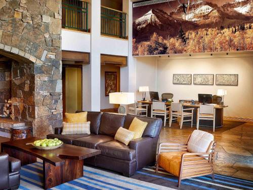 a living room with a couch and a stone fireplace at Fairmont Heritage Place, Franz Klammer Lodge in Telluride