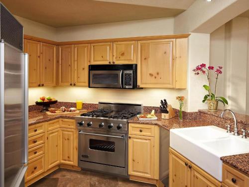 a kitchen with a stove and a microwave at Fairmont Heritage Place, Franz Klammer Lodge in Telluride
