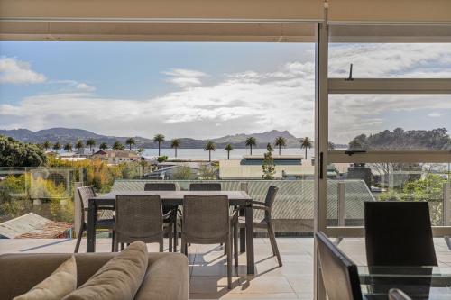 a living room with a table and chairs on a balcony at Esplanade Apartments in Whitianga