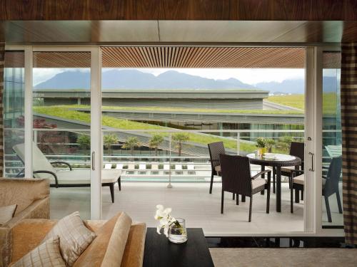 a living room with a table and chairs on a balcony at Fairmont Pacific Rim in Vancouver