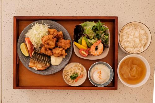 a tray with three plates of food and rice at Metrolux City Contemporary Hotel in Ho Chi Minh City