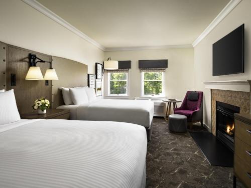 a hotel room with two beds and a fireplace at Fairmont Sonoma Mission Inn & Spa in Sonoma