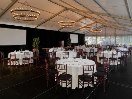 a banquet hall with white tables and chairs and chandeliers at Fairmont Sonoma Mission Inn & Spa in Sonoma