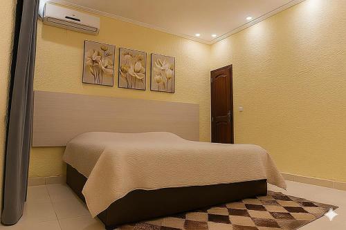 a bedroom with a bed and three pictures on the wall at Beautiful House - COP30 in Belém