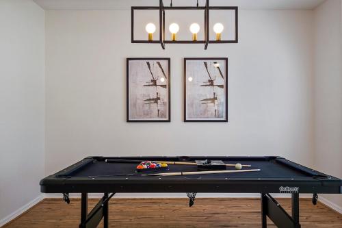 パーム・コーストにあるRenovated Heated Pool home with Game room and Bicyclesの3枚の絵が飾られた部屋にある卓球台