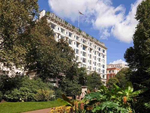 a white building with a flag on top of it at The Savoy in London