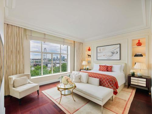 a bedroom with a bed and a couch and a window at The Savoy in London