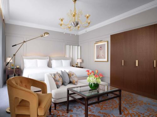 a living room with a bed and a couch and a table at The Savoy in London