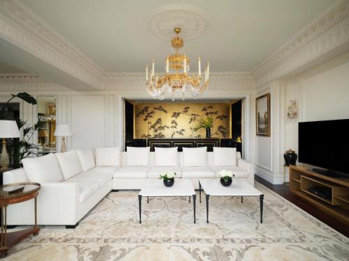 a living room with a white couch and a chandelier at The Savoy in London
