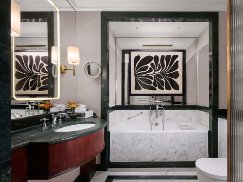 a bathroom with a tub and a sink at The Savoy in London