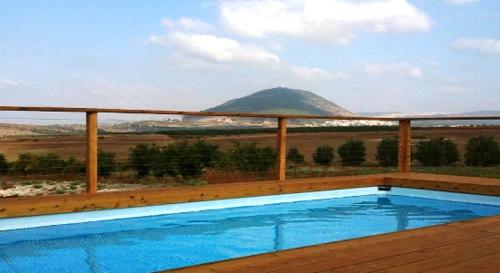 a swimming pool with a view of a mountain at Noach Batavor in Kefar Qish