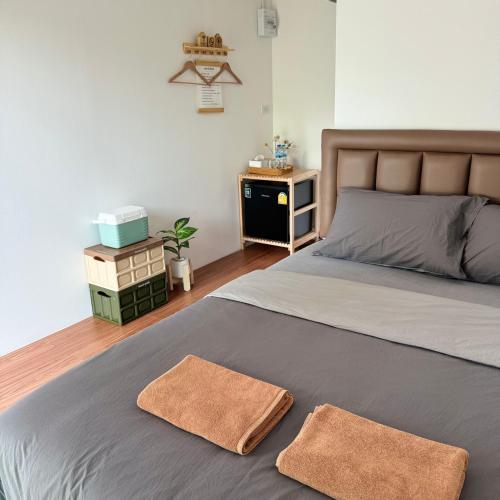 a bedroom with a bed with two towels on it at กางเขา แคมป์ปิ้ง in Ban Bung Mai