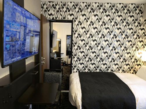 a hotel room with a bed and a tv at APA Hotel Ishigakijima in Ishigaki Island