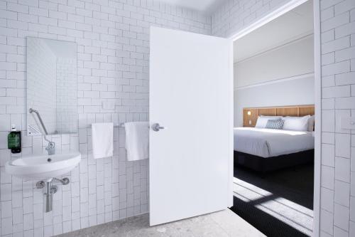 a white bathroom with a sink and a bed at Mortdale Hotel in Mortdale