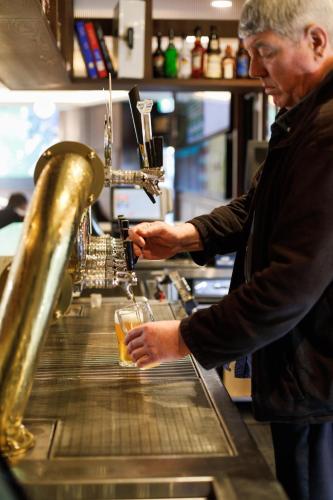 a man is making a drink at a bar at Mortdale Hotel in Mortdale