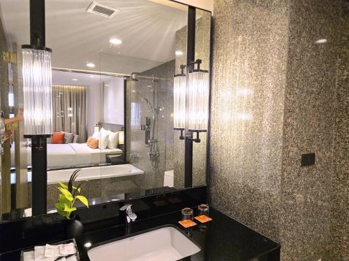 a bathroom with a sink and a large mirror at Sima Thani Hotel in Nakhon Ratchasima