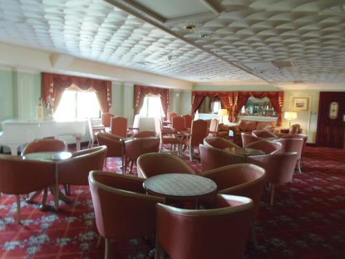 a dining room with chairs and tables in a hotel at Lakeside International Hotel in Camberley