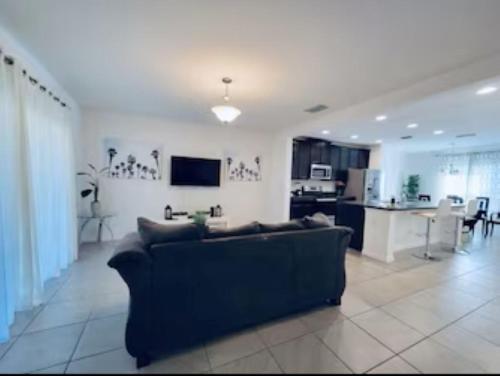 a living room with a couch and a kitchen at Primrose Villa in Davenport