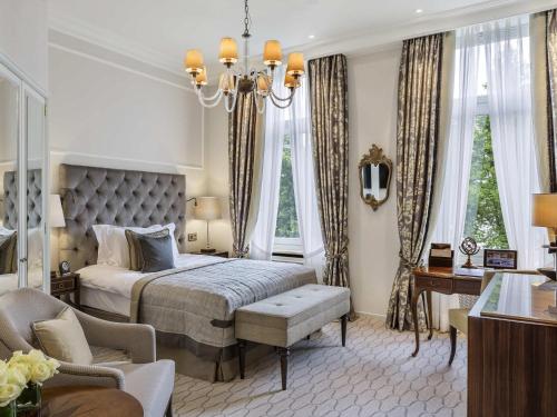 a bedroom with a bed and a chandelier at Fairmont Hotel Vier Jahreszeiten in Hamburg