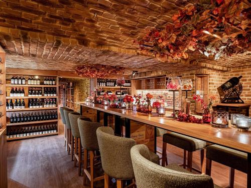 a bar with chairs and a counter with wine bottles at Fairmont Hotel Vier Jahreszeiten in Hamburg
